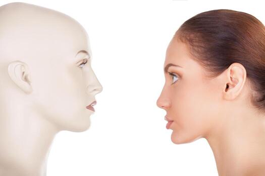 Face your problem. Side view of beautiful young woman standing in front of the mannequin and looking at it while standing isolated on white background photo