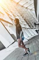 Enjoying her style. Full length of beautiful young woman in casual wear looking away while standing outdoors photo