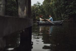 Enjoying every minute together. Beautiful young couple relaxing while enjoying romantic date on the lake photo