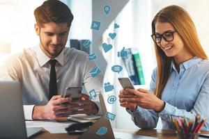 Technologies making people get closer. Montage of two images with men and woman looking at their smart phones and smiling while sitting in different places photo