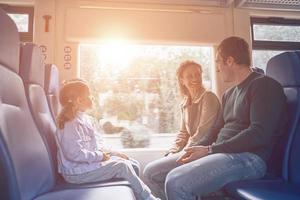 Family with little girl smiling while enjoying train journey photo