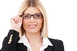 Feeling confident. Confident mature businesswoman adjusting her glasses and smiling while standing isolated on white photo