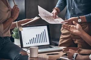 Close up of modern people discussing business while working in the office photo