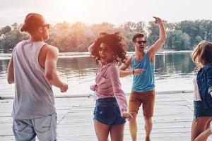 divirtiéndose. grupo de jóvenes con ropa informal sonriendo y gesticulando mientras disfrutan de la fiesta en la playa foto