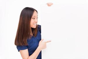 Beauty pointing copy space. Beautiful young Asian woman pointing copy space and smiling while standing isolated on white photo