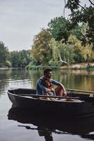 Leaving worries behind. Beautiful young couple embracing and smiling while enjoying romantic date on the lake photo