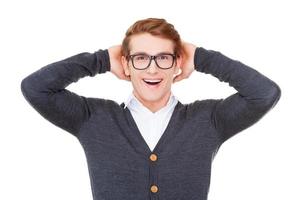 lleno de ideas frescas. alegre joven sosteniendo la cabeza en las manos y sonriendo a la cámara mientras está de pie aislado en blanco foto