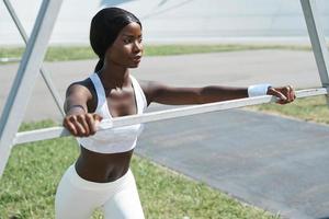 bella joven africana vestida con ropa deportiva relajándose después de entrenar al aire libre foto