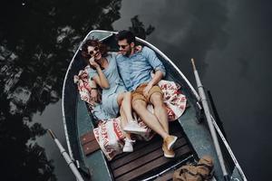 So much fun together Top view of beautiful young couple embracing and smiling while lying in the boat photo