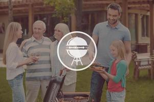 Family barbecue. Happy family of five people barbecuing meat on grill on the back yard photo