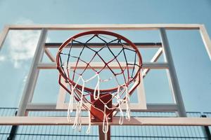 Shot of basketball hoop with sky in the background outdoors photo