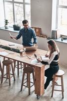 analizando las ventas. vista superior de los jóvenes colegas que trabajan mientras pasan tiempo en el espacio de trabajo creativo foto