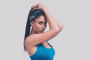 Gorgeous beauty. Studio shot of attractive young woman in blue swimsuit posing against grey background and looking at camera photo