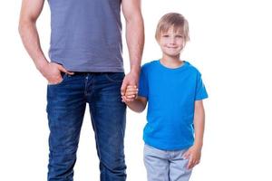 padre e hijo. padre e hijo tomados de la mano mientras están aislados en blanco foto