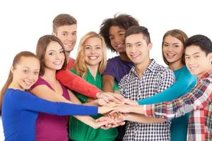 We are strong when we together. Cheerful group of multi-ethnic people holding hands together and smiling at camera while standing isolated on white photo