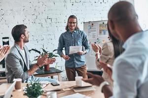 Fresh information. Group of business people clapping and smiling while standing in the board room photo
