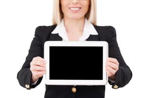 Copy space on her tablet. Cropped image of mature businesswoman showing her digital tablet while standing isolated on white photo