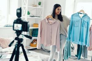 Beautiful young woman in casual clothing making social media video while spending time at home photo