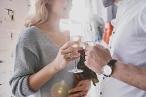 Celebrating something special. Close up of young couple drinking champagne and smiling while spending time in the bedroom photo