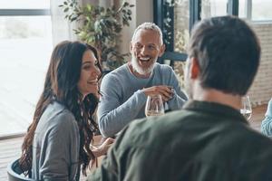 Happy family communicating and smiling while having dinner together photo