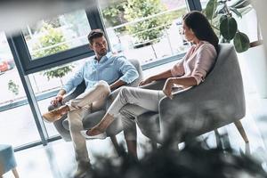 siempre juntos. hermosa pareja joven mirándose mientras se sienta en el interior foto