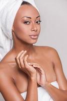 Pure beauty. Beautiful young Afro-American shirtless woman keeping her hands clasped and looking at camera while Isolated on gray background photo