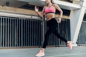 Confident young woman in sports clothing running outdoors photo