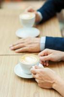 Drinking coffee together. Top view of couple drinking coffee together photo