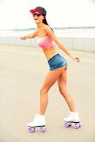 Girl roller skating. Full length of happy young woman roller skating photo