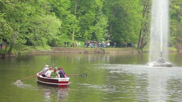 people traveling by boat on the lake near the big fountain video