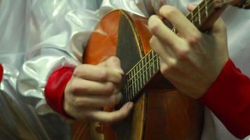 mão humana tocando as cordas dombra video