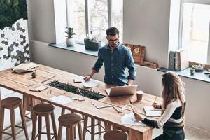 cuidar de los negocios. vista superior de los jóvenes colegas que trabajan mientras pasan tiempo en el espacio de trabajo creativo foto