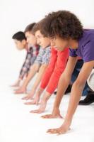 On starting line. Group of young multi-ethnic men standing on starting line and looking forward while isolated on white photo