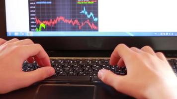 Hands of a young man typing on the keyboard of a dark coloured notebook video