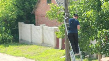 homme travaillant avec l'équipement sur le poteau video