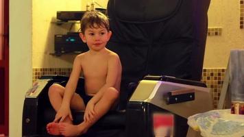 Boy playing on massage chair indoor video