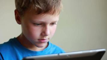 Close up view of young boy playing game on electronic device video