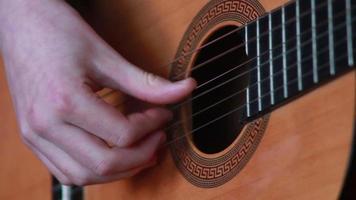 menselijk hand- spelen Aan de strings van de gitaar