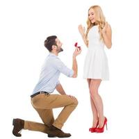 Will you marry me Full length of man making proposal to his girlfriend while standing at his knee and giving an engagement ring photo