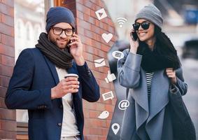 I will be in five minutes Montage of two images of men and woman talking on their smart phones and smiling while standing in different places outdoors photo