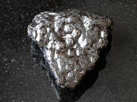 piedra de mineral de riñón de hematita en bruto sobre negro foto