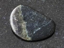 polished Olivenite stone on dark background photo