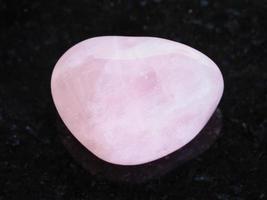 tumbled Rose Quartz gem stone on dark photo