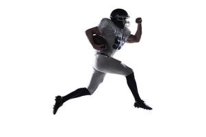 Forward to the victory  Side view of American football player holding ball and jumping against white background photo