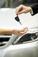 Drive carefully Close-up shoot of the car salesman hand giving a key to the owner photo