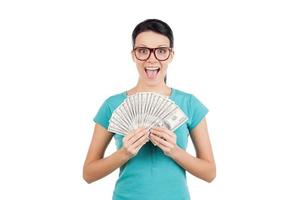 I am rich Happy young woman in glasses holding money in her hands and looking at camera while standing isolated on white photo