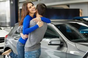 Thank you dear Young beautiful woman hugging her boyfriend thanks for the new car photo