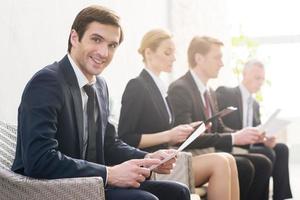 I will get this job Four people in formalwear waiting in line while one of them looking at camera and smiling photo