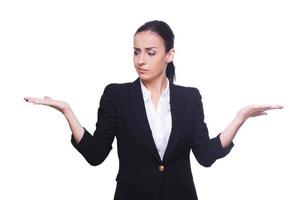 Hard choice. Thoughtful young woman in formalwear holding copy space in both hands while standing isolated on white photo