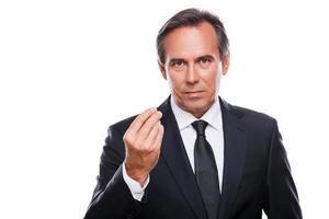 Business expert. Confident mature man in formalwear looking at camera and gesturing while standing against white background photo